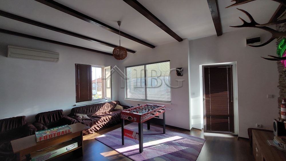 Bright living room with large windows and cozy furniture in a family house in Burgas.