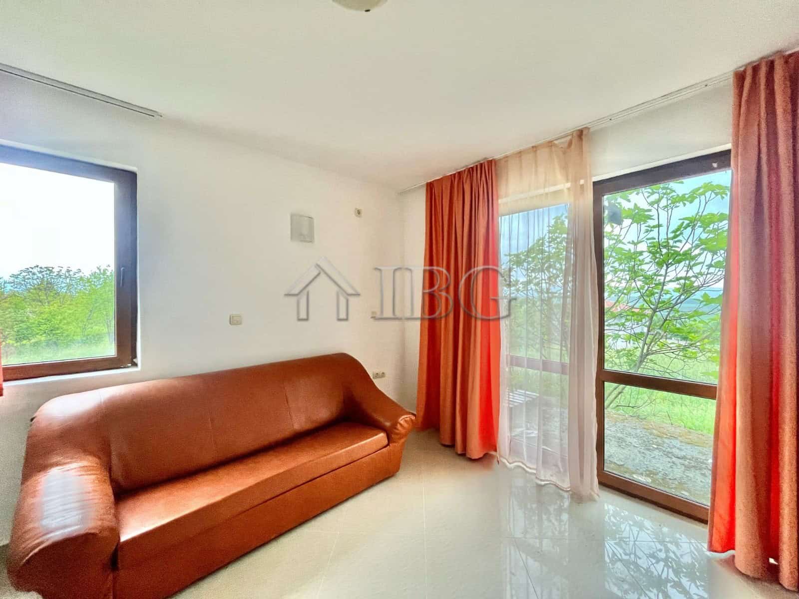 Bright living room with large windows and balcony access, offering scenic views in Aleksandrovo, Bur.