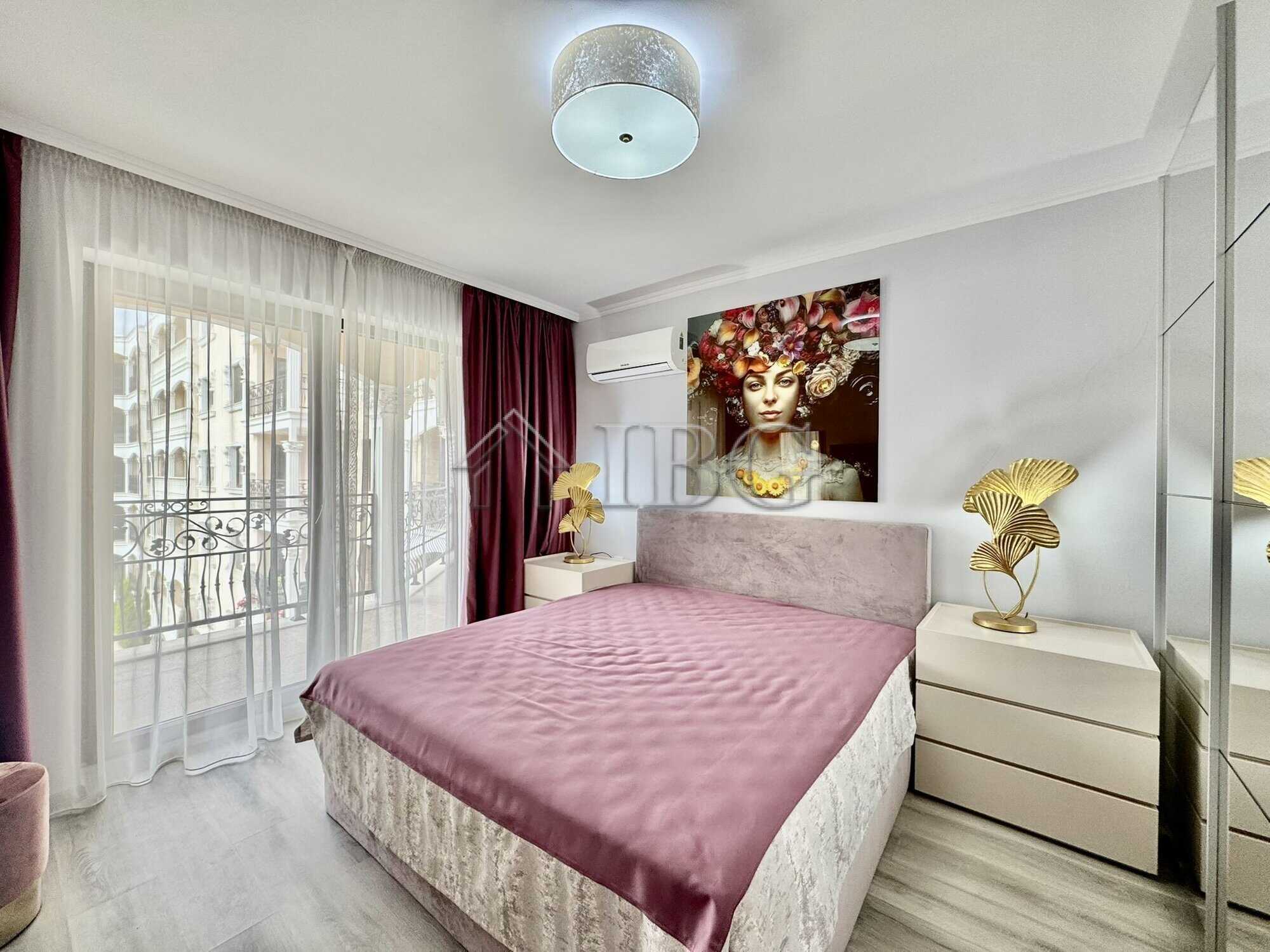 Bright bedroom featuring a large bed, elegant artwork, and access to a balcony with scenic views.