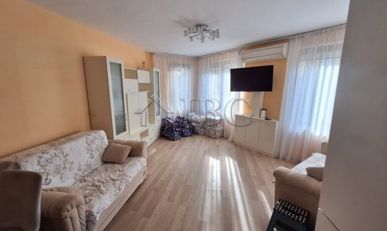 Bright living room of a 2-bedroom apartment in Ravda with large windows and modern furnishings.