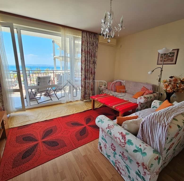 Sea view living room with balcony overlooking the beach and ocean.