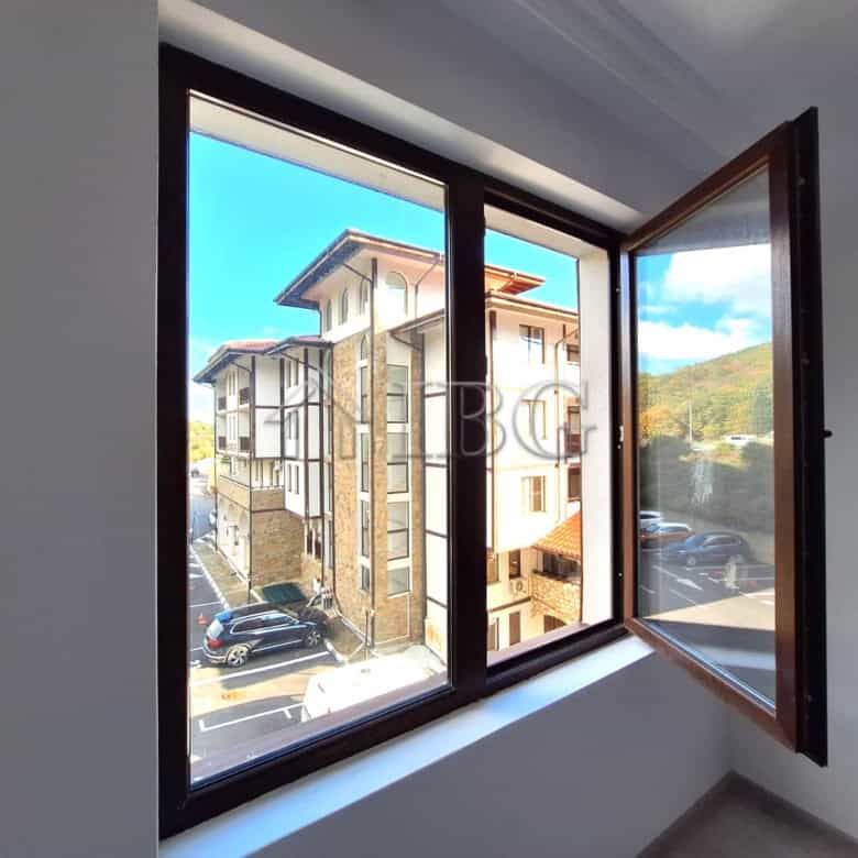 Apartment window showcasing forest and partial sea views in Sveti Vlas, Bulgaria.