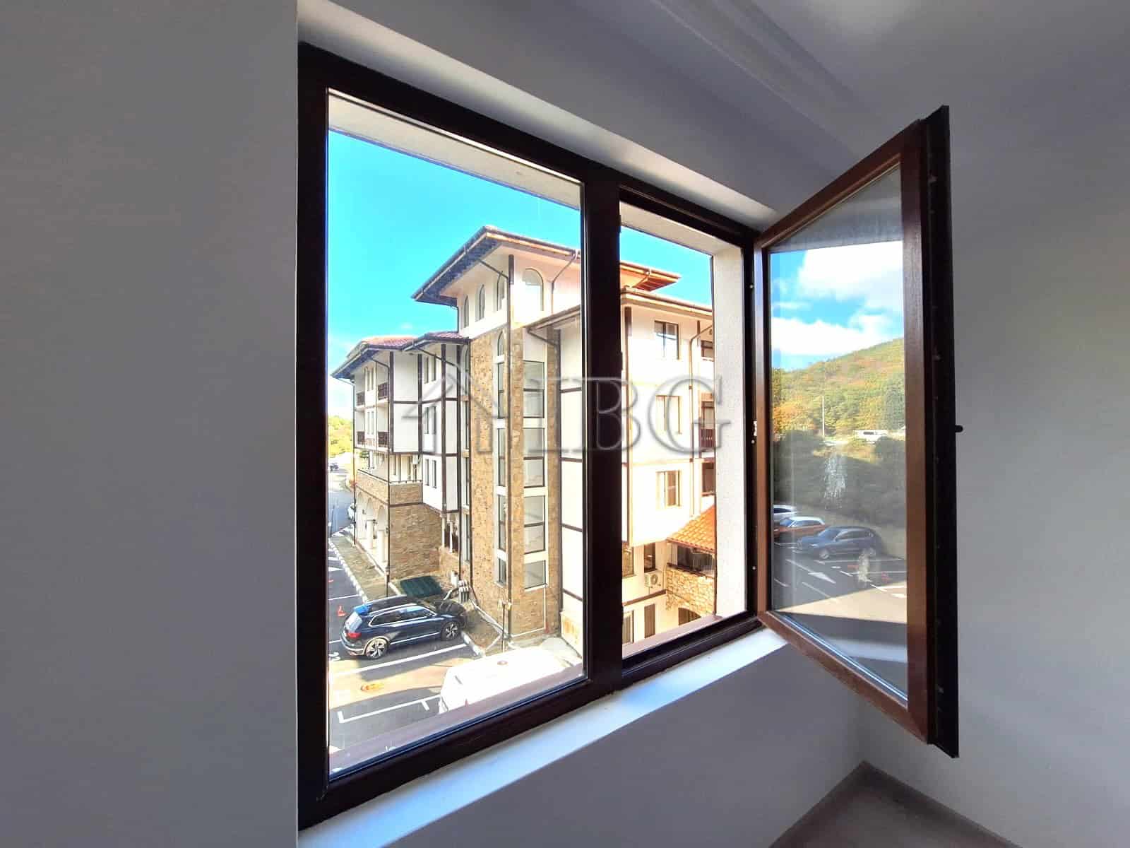 Apartment window showcasing forest and partial sea views in Sveti Vlas, Bulgaria.