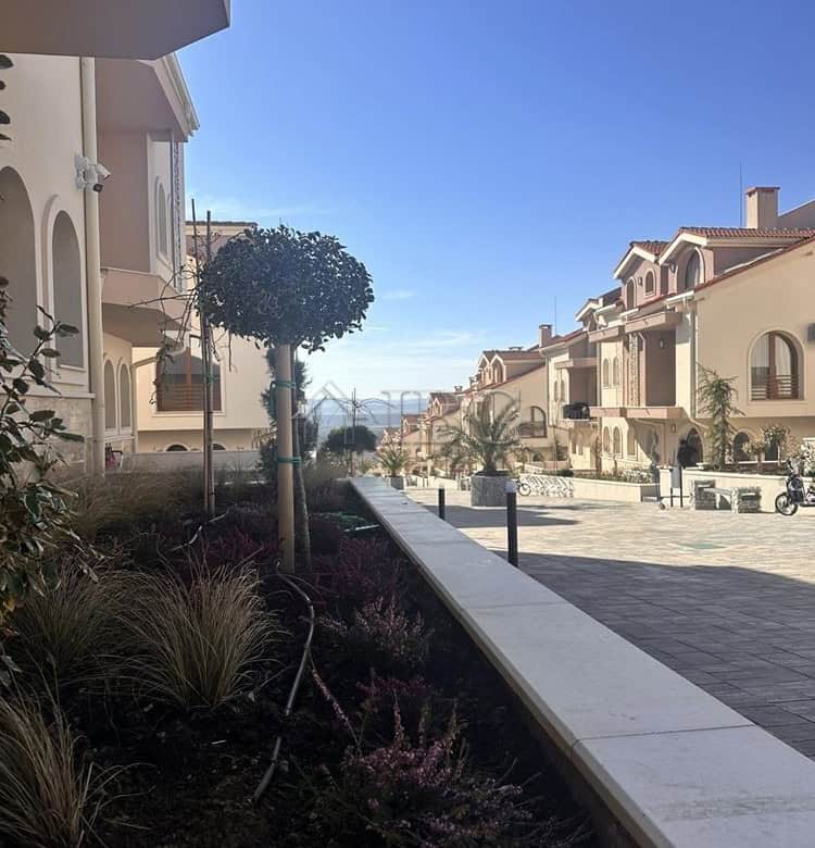 Beautiful view of a new apartment complex with landscaped garden and clear blue sky in Kosharitsa.