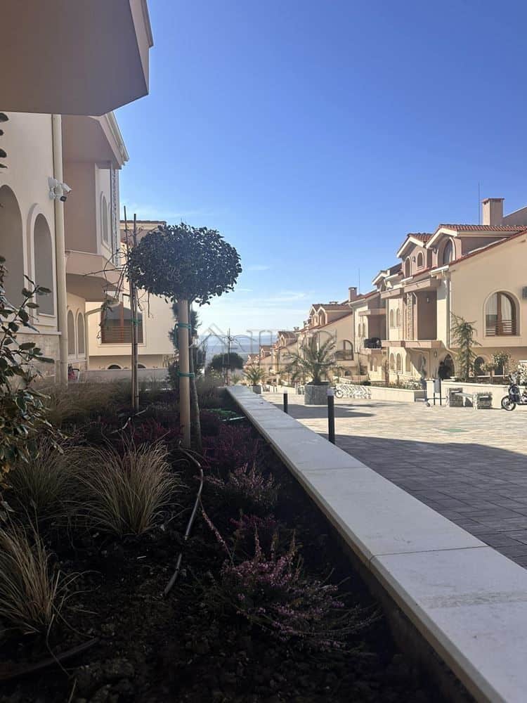 Beautiful view of a new apartment complex with landscaped garden and clear blue sky in Kosharitsa.