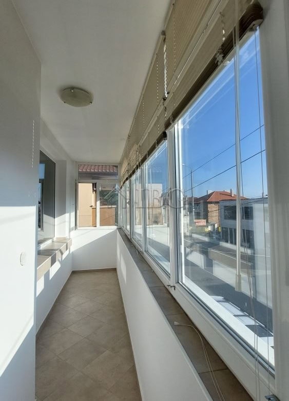 Enclosed balcony with large windows in a family house in Burgas, offering bright, airy space.
