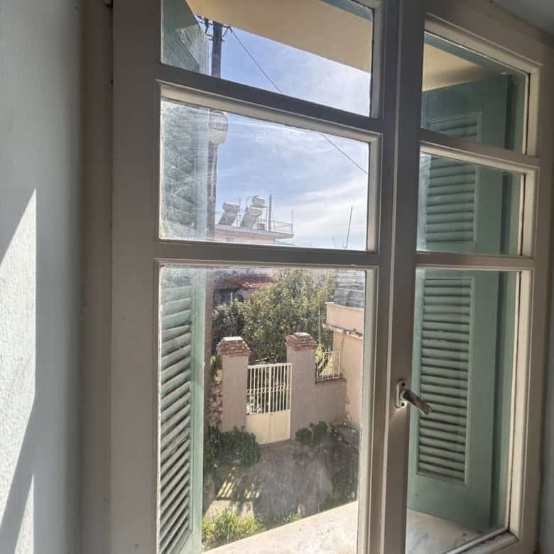 Bright interior view through a window with green shutters.