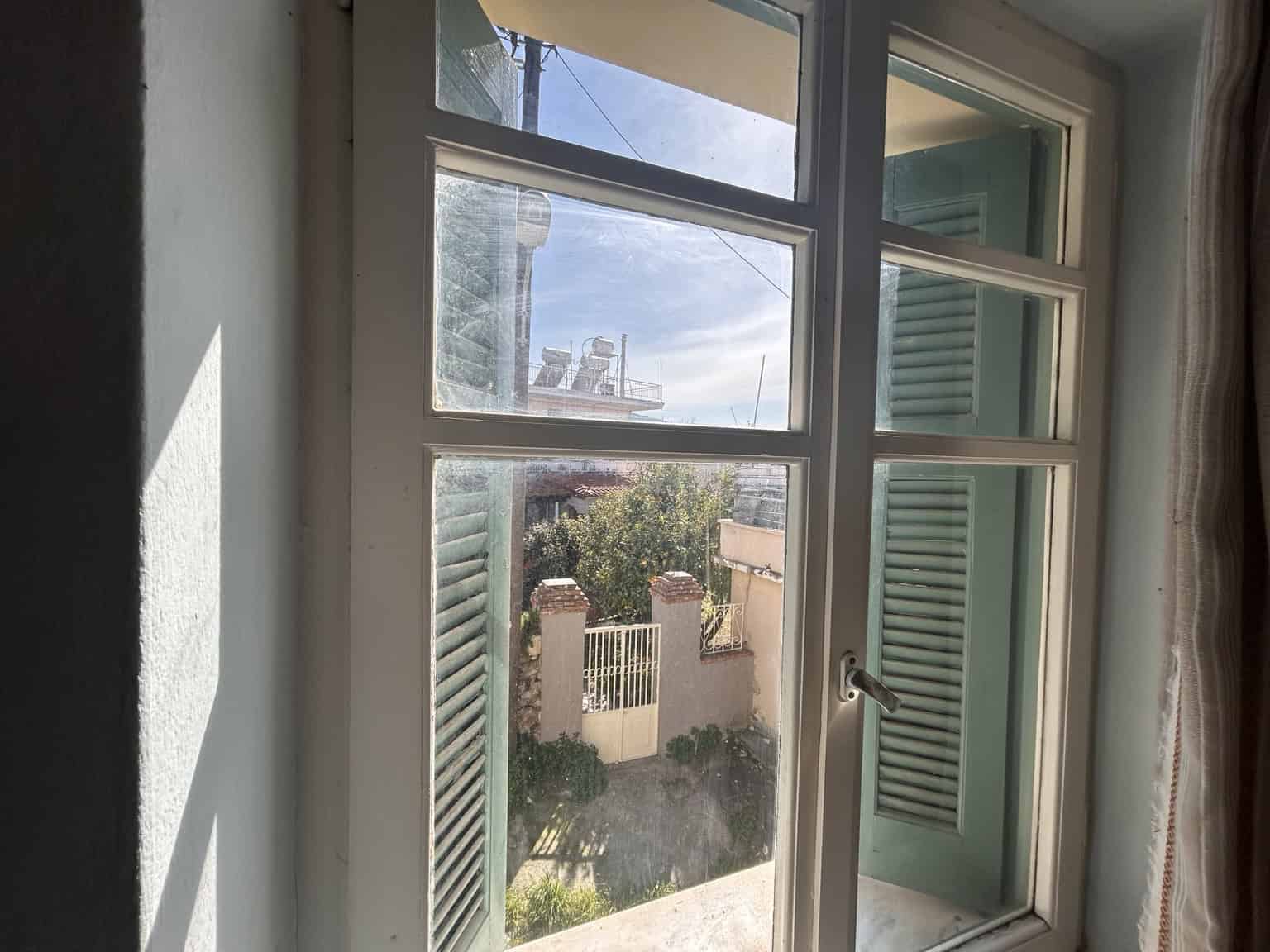 Bright interior view through a window with green shutters.