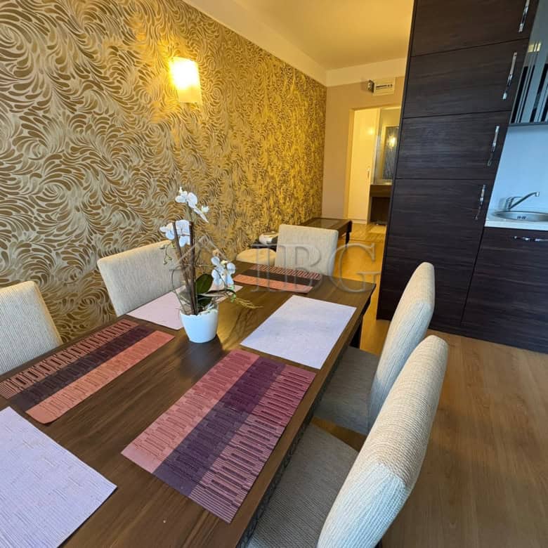 Spacious dining room featuring a stylish table, six chairs, and decorative wallpaper in a luxury apa.