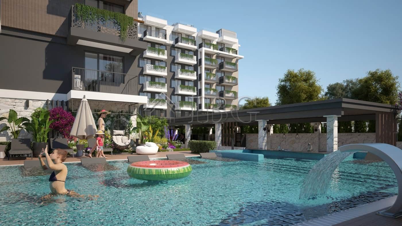 Contemporary apartment building with swimming pool and lush garden area in Sunny Beach.