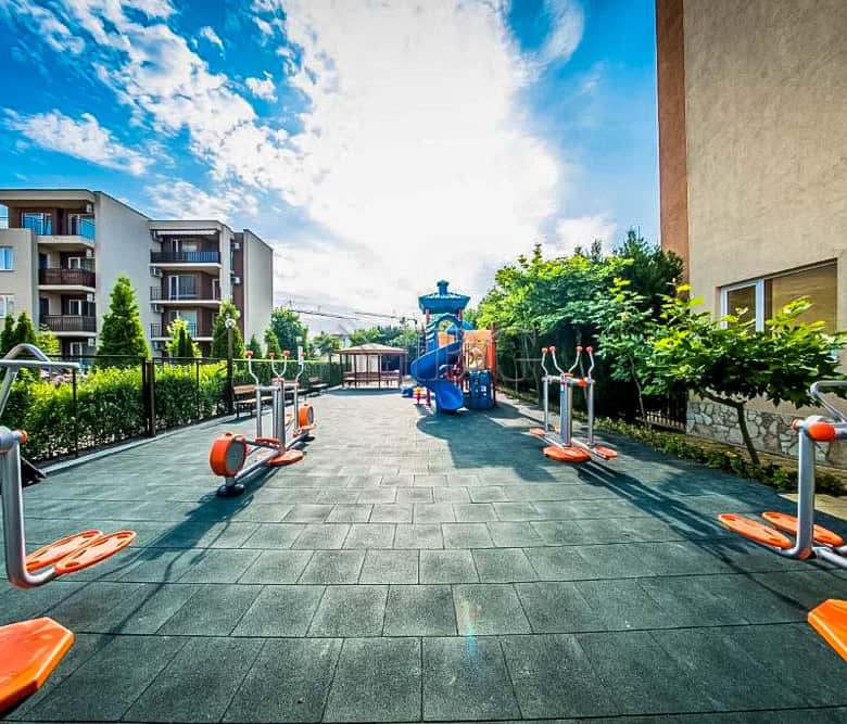 Outdoor fitness area at Orchid Fort Club with pool view and exercise equipment.