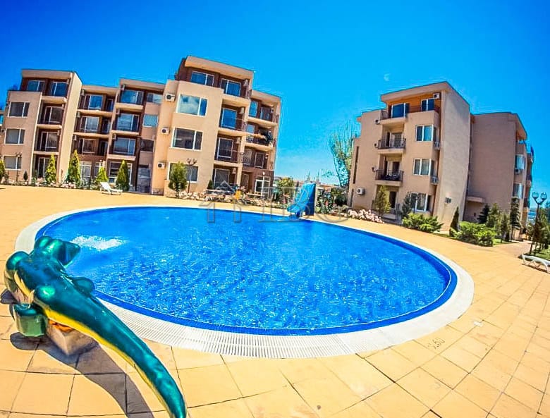 Pool view at Orchid Fort Club with a playful dolphin float in Sunny Beach. Modern residential buildi.