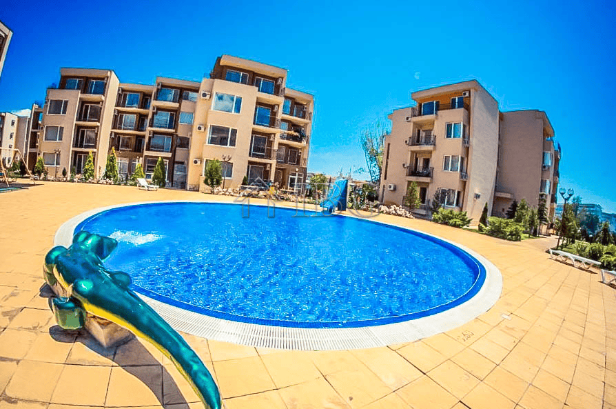 Pool view at Orchid Fort Club with a playful dolphin float in Sunny Beach. Modern residential buildi.
