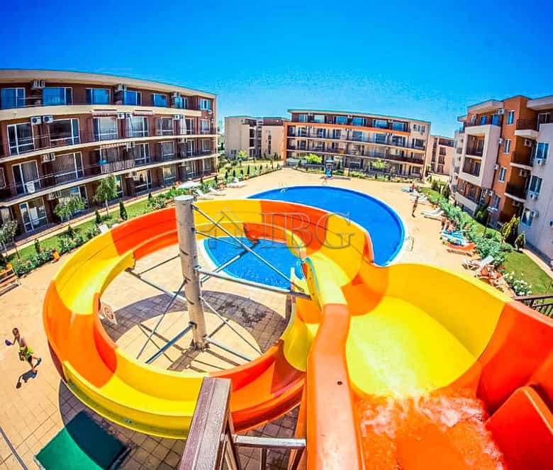 Bright pool view with water slides and surrounding residential buildings in Sunny Beach.