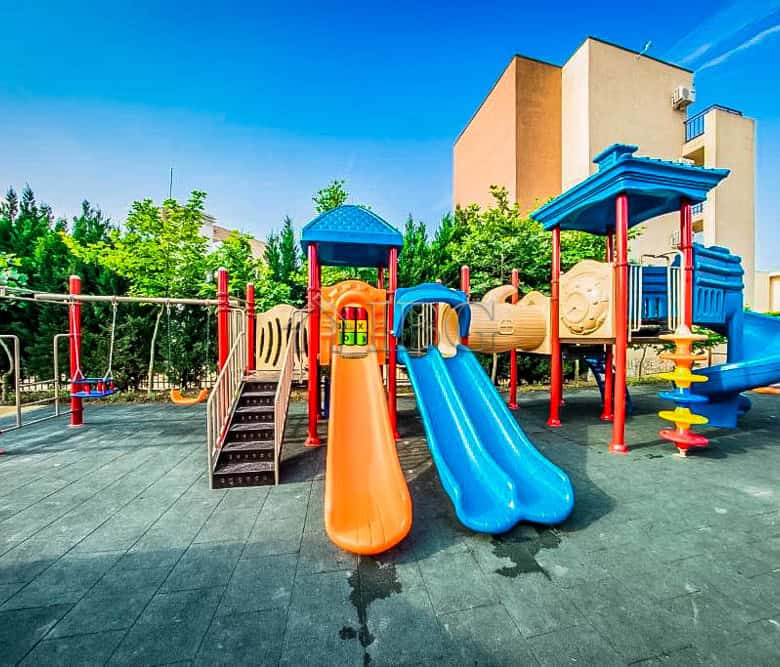 Bright outdoor playground at Orchid Fort Club with colorful slides and climbing structures.