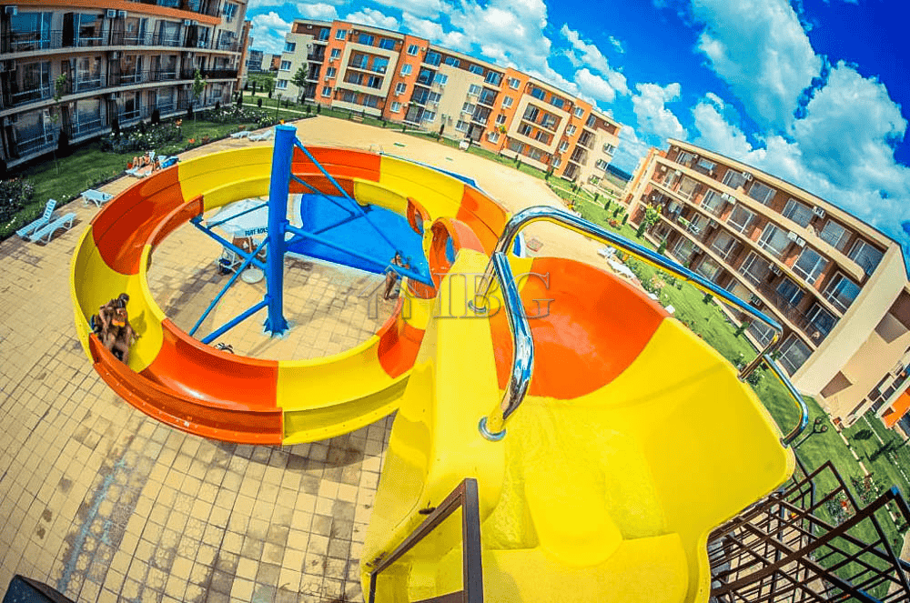 Water slide with pool view at Orchid Fort Club, Sunny Beach. Perfect for family fun and relaxation i.