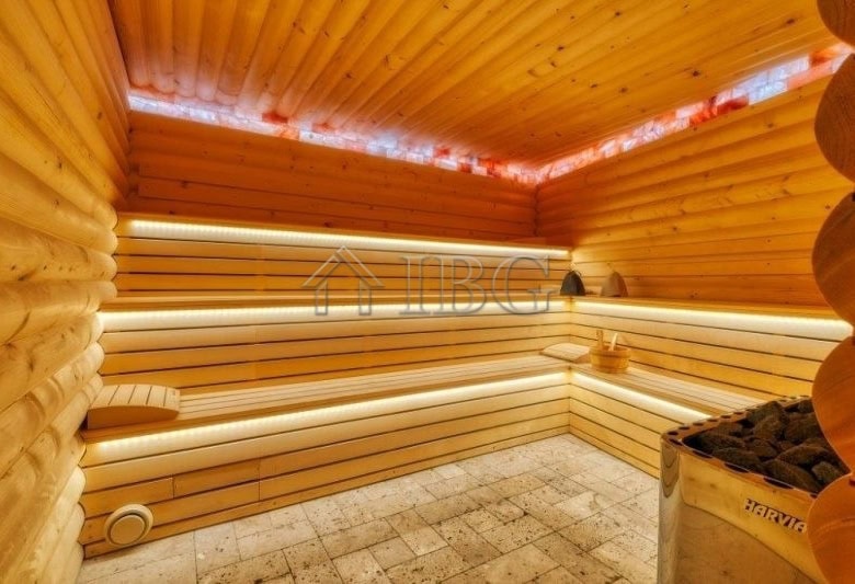 Interior view of a traditional wooden sauna with benches and ambient lighting.
