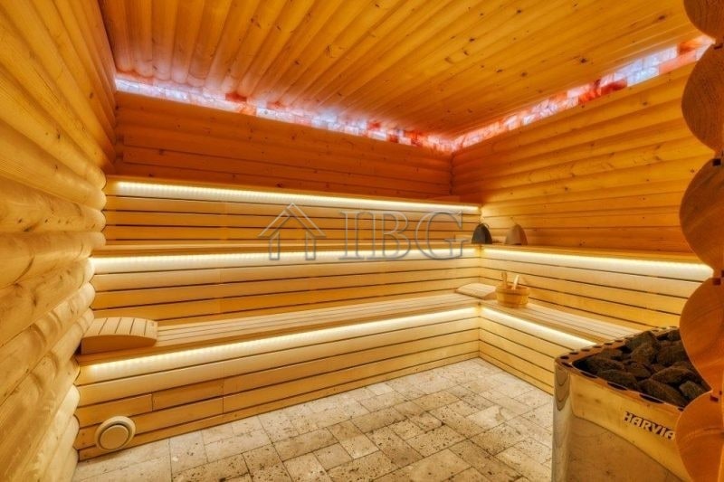 Interior view of a traditional wooden sauna with benches and ambient lighting.