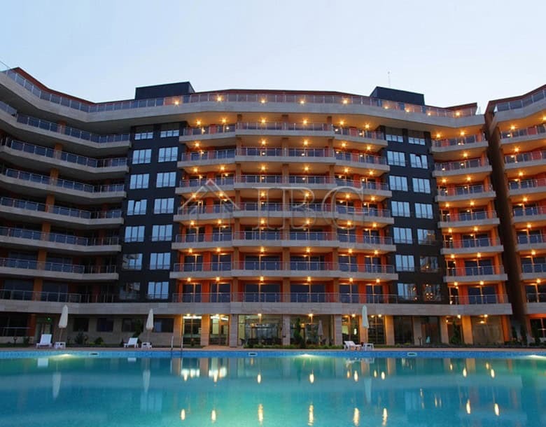 Bright apartment building with balconies overlooking the pool.
