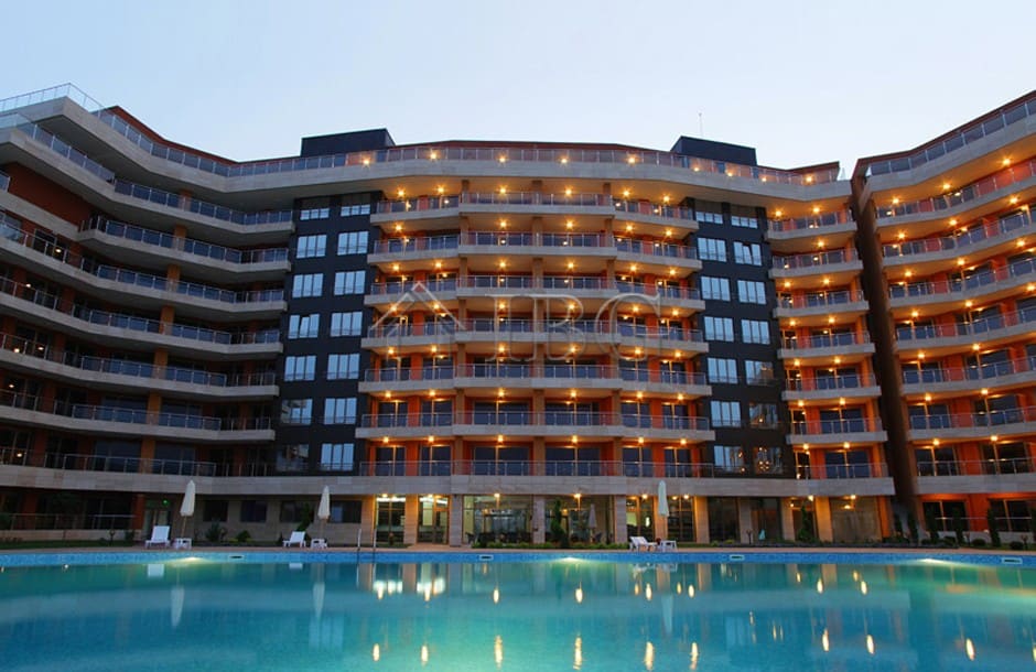 Bright apartment building with balconies overlooking the pool.
