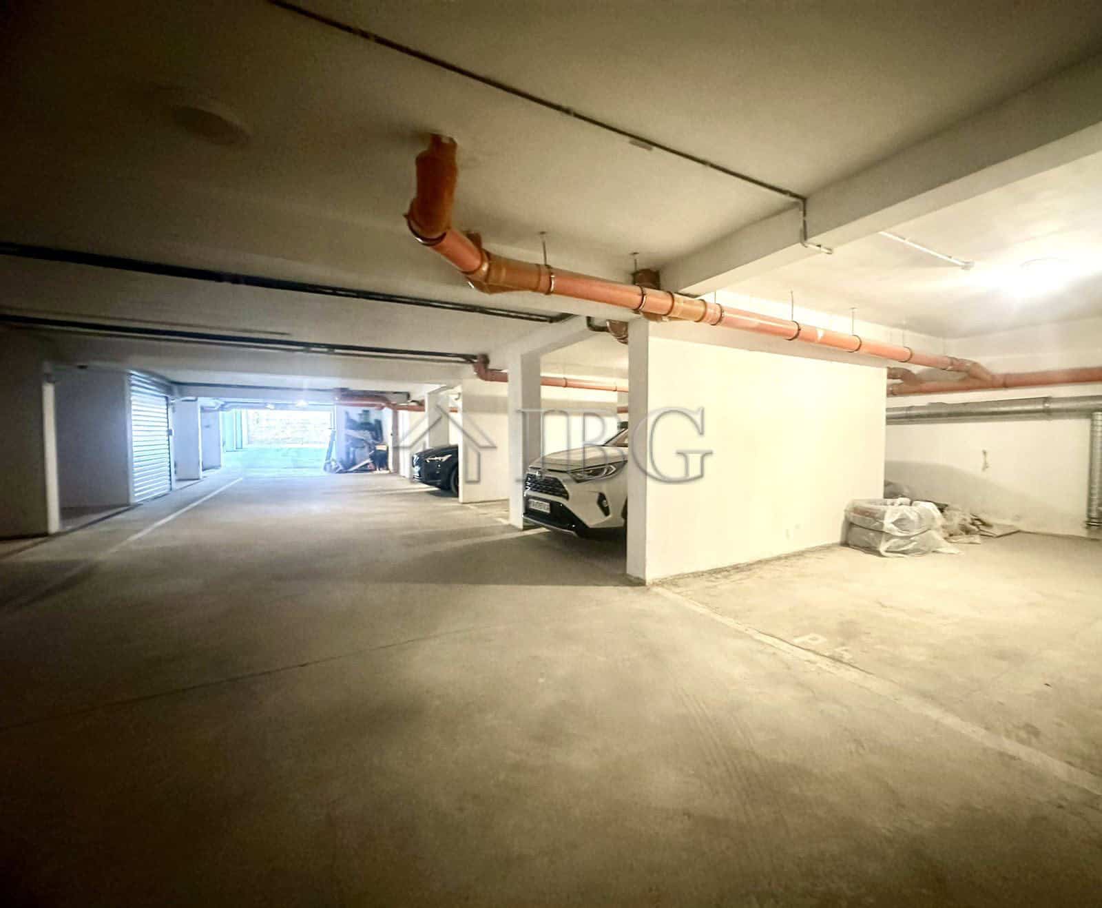 Parking space in Venera Palace, Sunny Beach, Bulgaria, with visible pipes and parked cars.