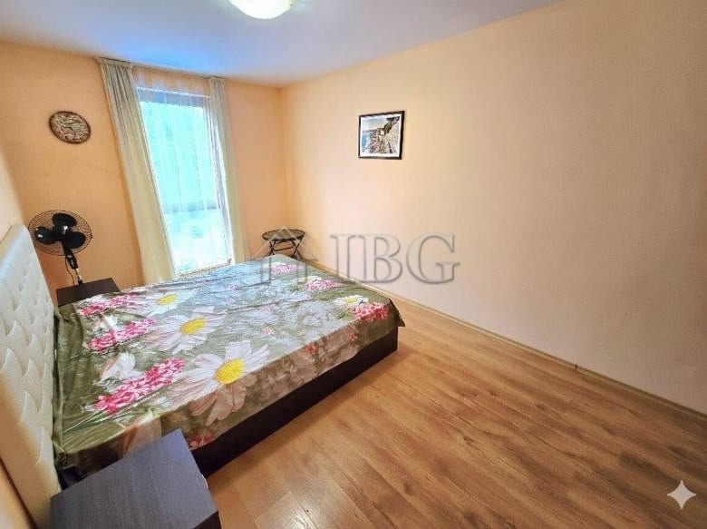Bright bedroom with pool view, large window, and simple decor in Sunny Beach.