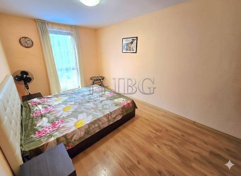Bright bedroom with pool view, large window, and simple decor in Sunny Beach.