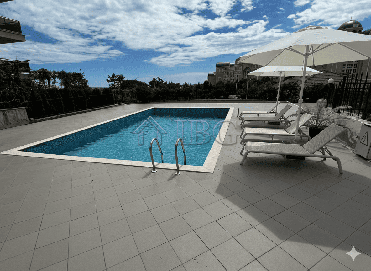 Pool with clear blue water, sun loungers, and umbrellas on a sunny day.
