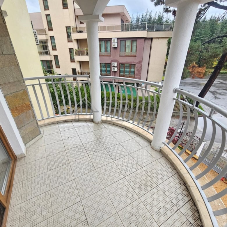 Balcony overlooking pool and surrounding buildings in a modern apartment. Perfect for relaxing and e.