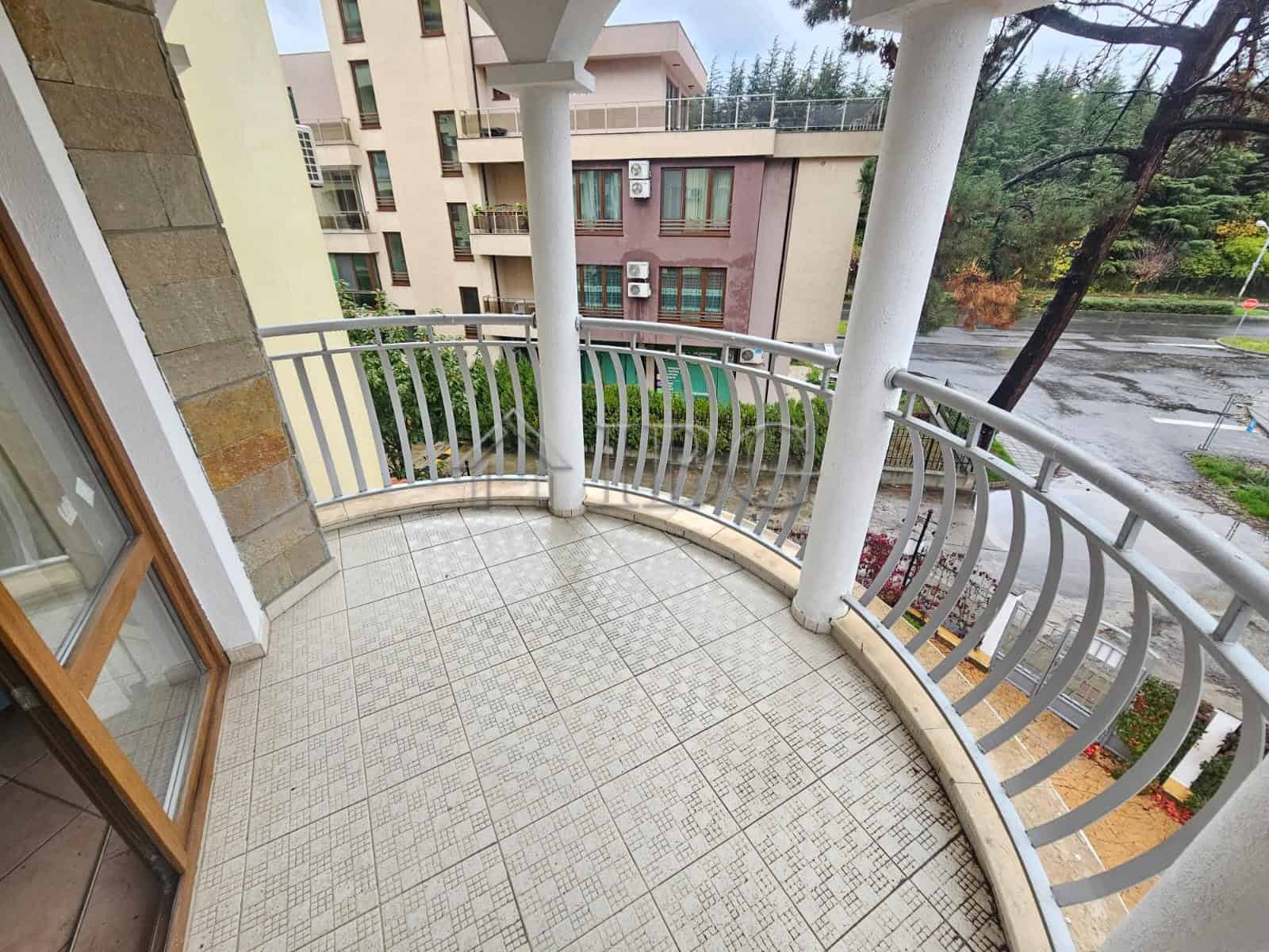 Balcony overlooking pool and surrounding buildings in a modern apartment. Perfect for relaxing and e.