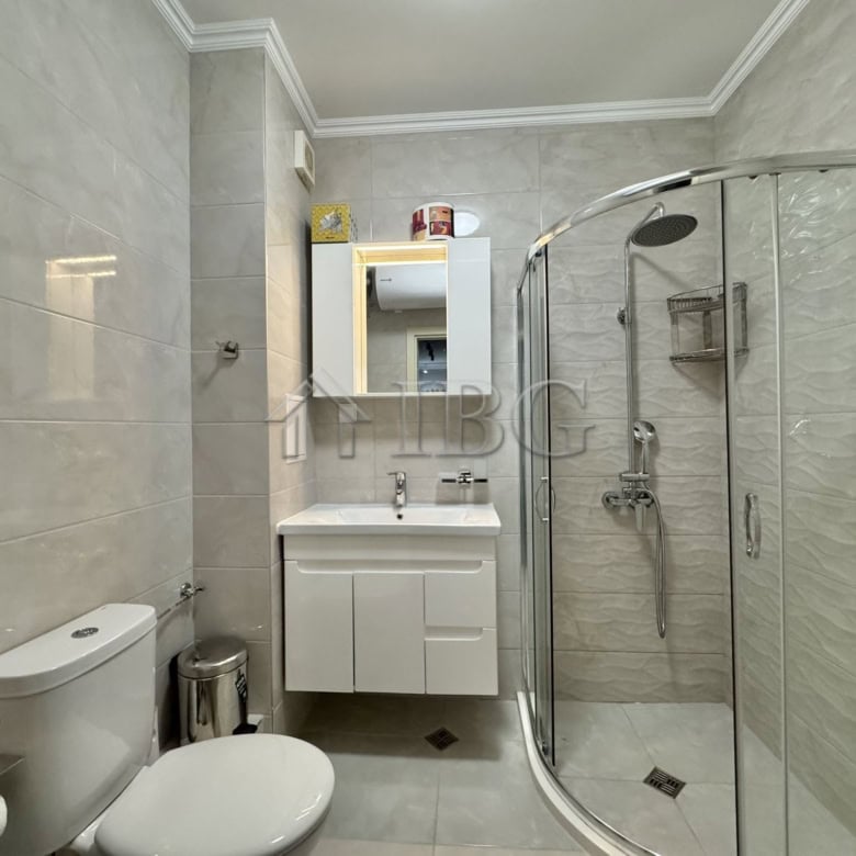 Bathroom with shower, toilet, and sink in a contemporary apartment.