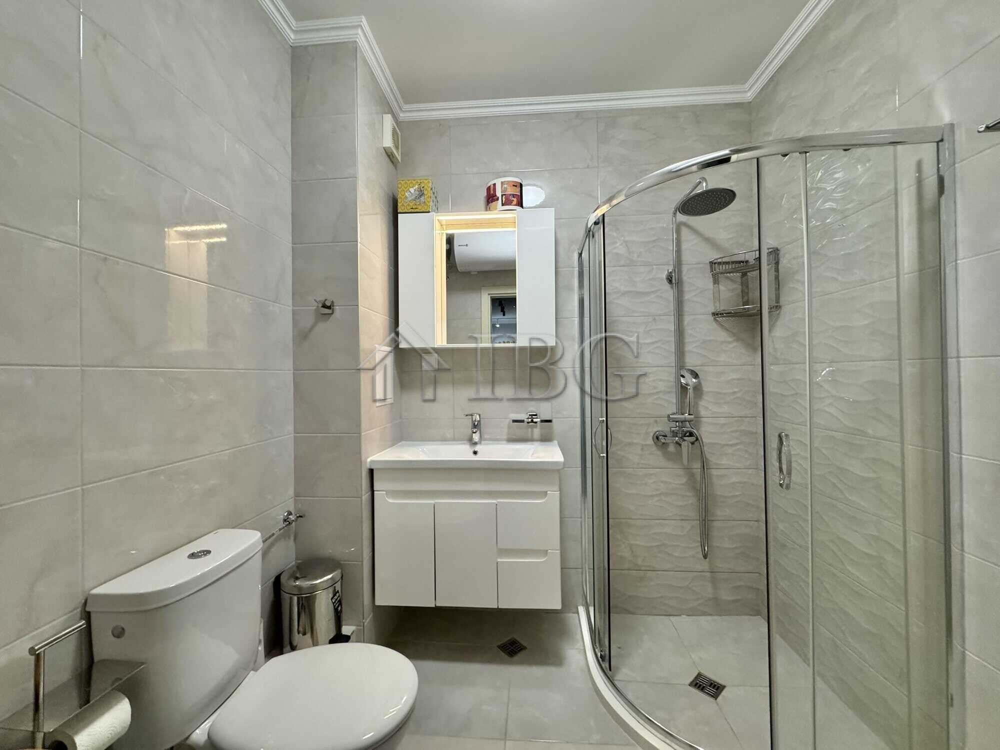 Bathroom with shower, toilet, and sink in a contemporary apartment.