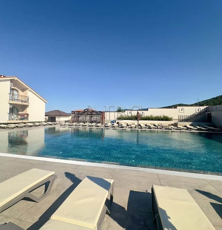 Poolside view of the large swimming pool and sun loungers in the Grand Village complex, Kosharitsa.