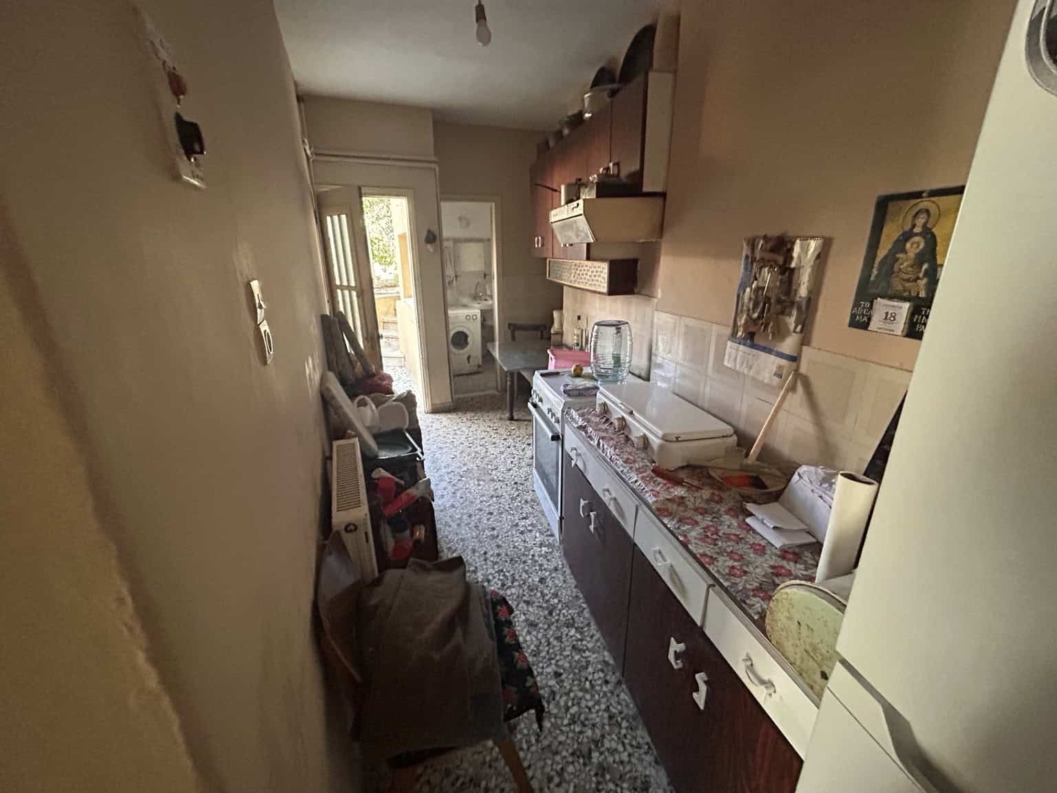 Small kitchen with traditional decor and appliances in a Mediterranean-style house.