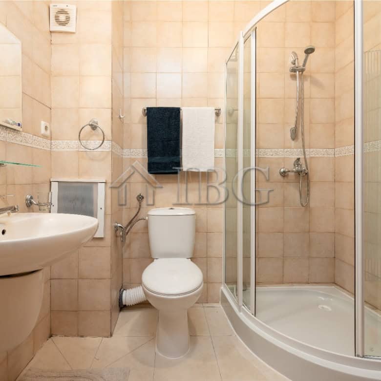 Bright bathroom with shower, toilet, and sink in renovated Sunny Beach apartment.