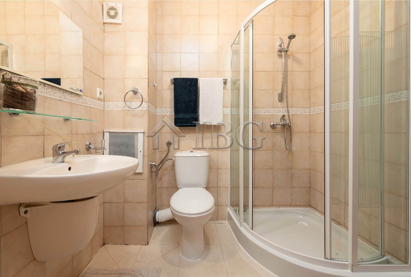 Bright bathroom with shower, toilet, and sink in renovated Sunny Beach apartment.