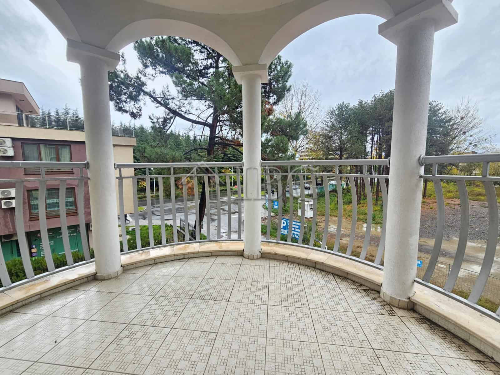 Balcony overlooking lush garden and trees, perfect for relaxing outdoors.