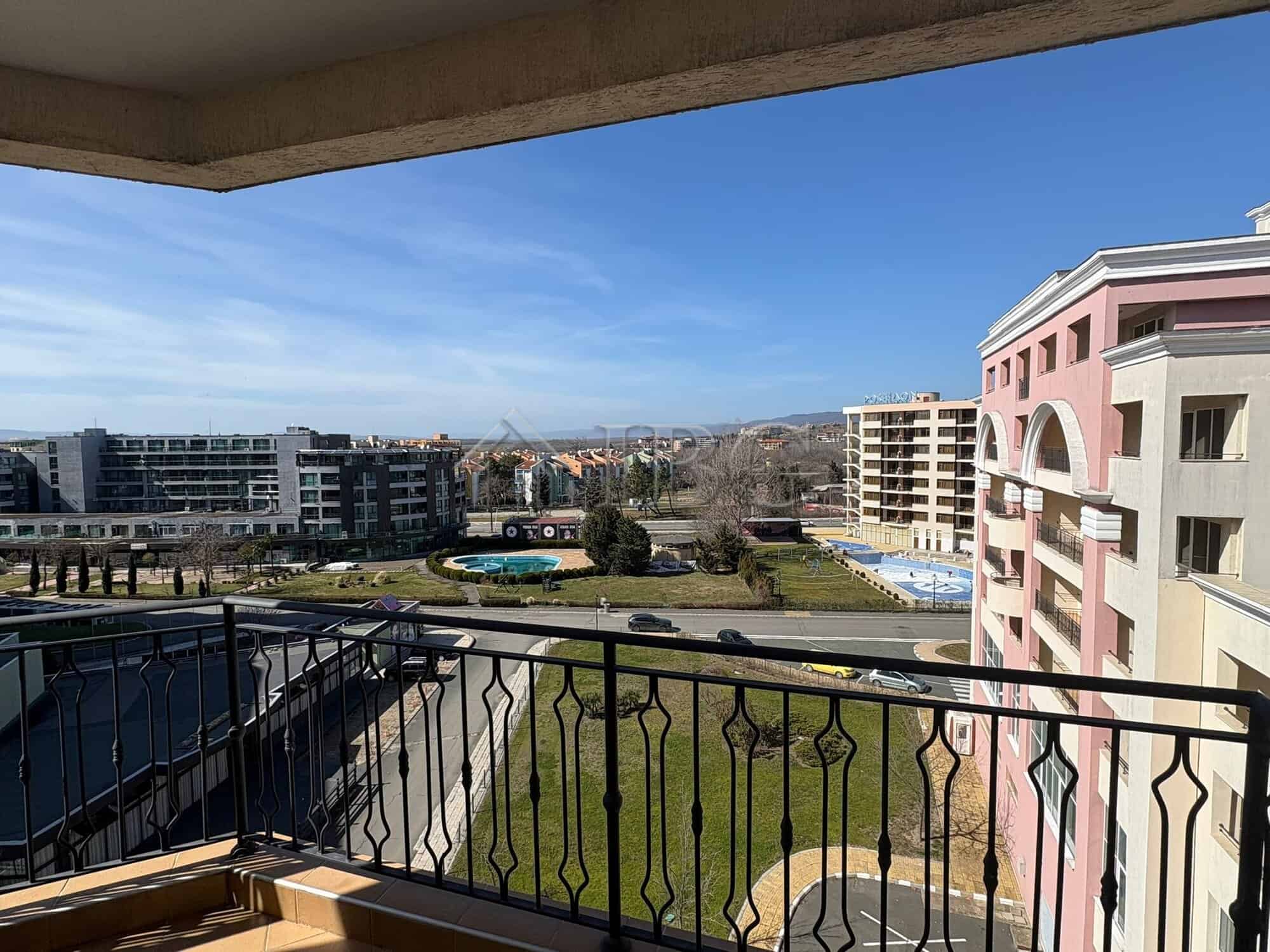 Balcony view of Sunny Beach cityscape with modern buildings and green spaces.
