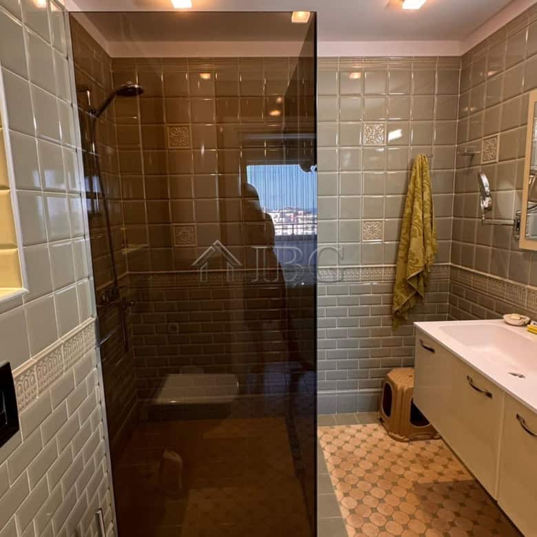 Bathroom with glass shower enclosure and sea view in Sveti Vlas.