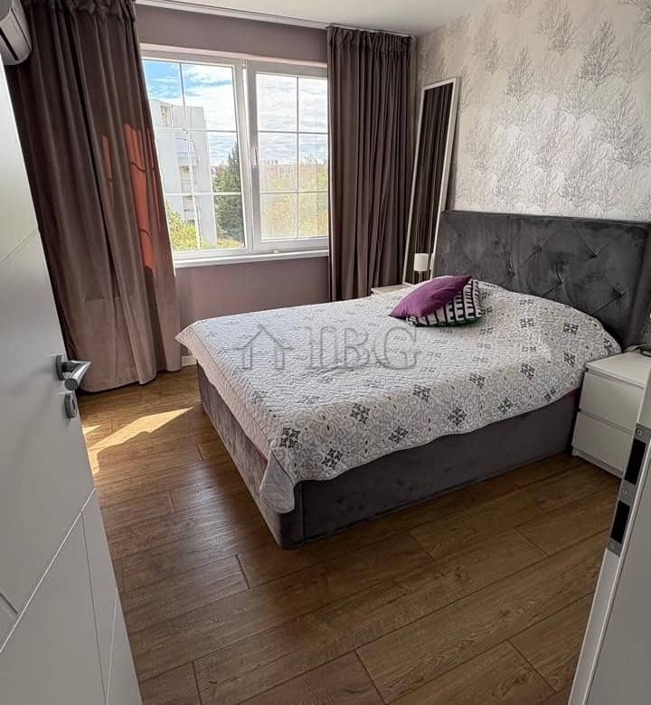 Bright bedroom with large window overlooking the pool and yard in Pomorie Residence.