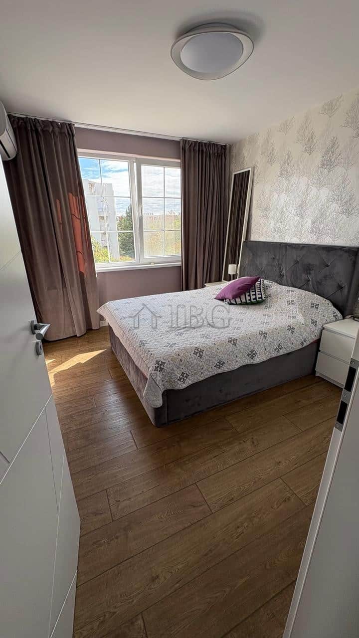 Bright bedroom with large window overlooking the pool and yard in Pomorie Residence.