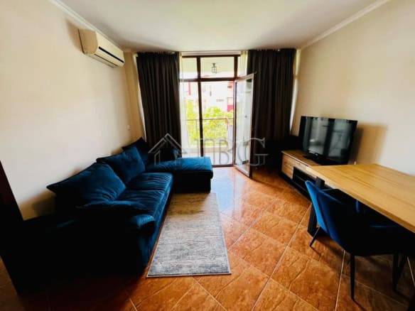 Bright living room with sofa, TV, and balcony view in Sveti Vlas.