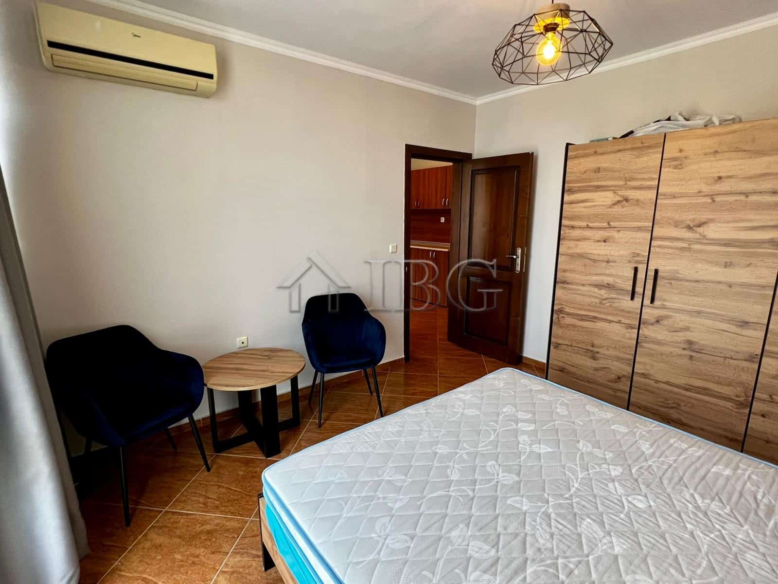 Spacious bedroom with wardrobe, seating area, and modern decor in Helios Complex, Sveti Vlas.