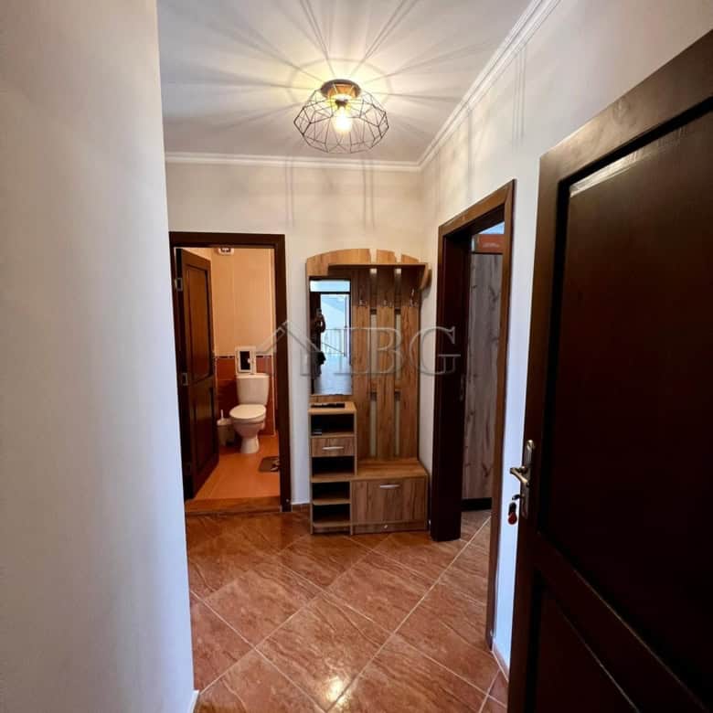 Bright hallway in Helios Complex apartment with modern decor and wooden accents.
