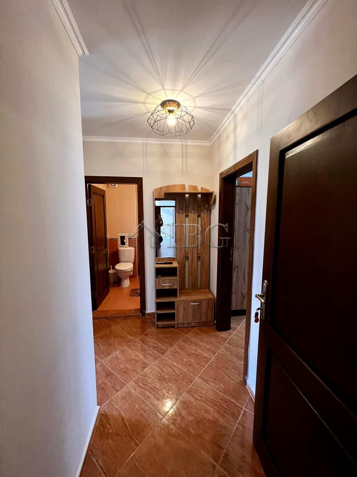 Bright hallway in Helios Complex apartment with modern decor and wooden accents.
