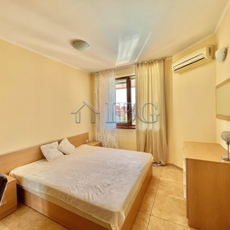 Apartment interior with a large bed, window, and air conditioning in Ravda.