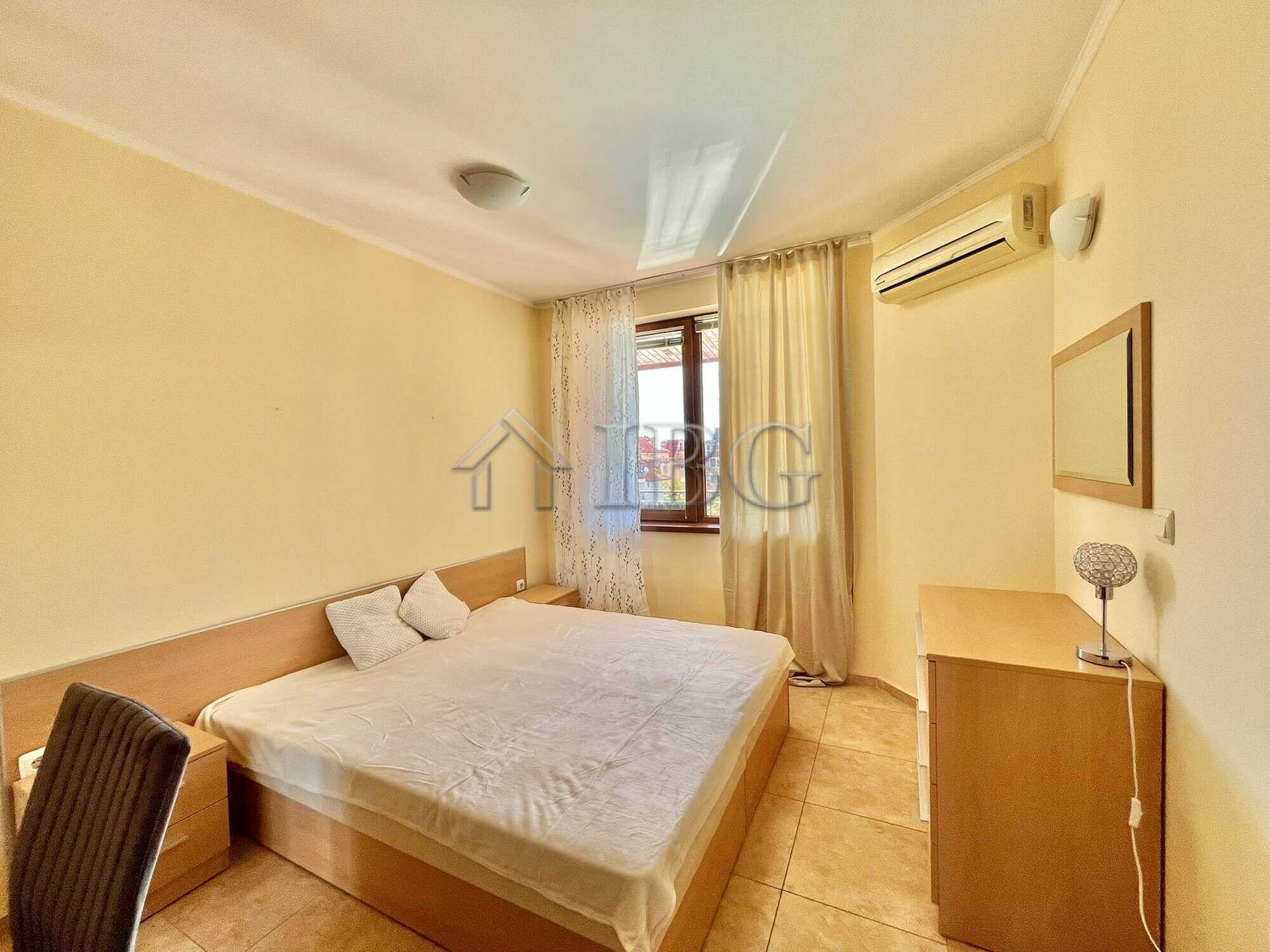 Apartment interior with a large bed, window, and air conditioning in Ravda.
