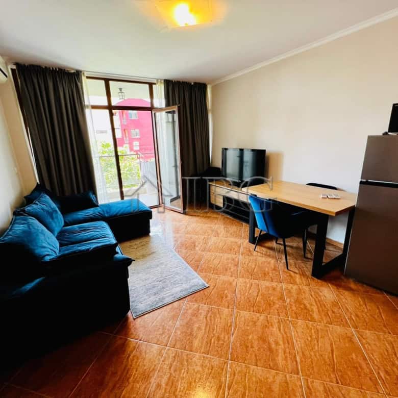 Spacious living room with sofa, TV, and balcony access in Helios Complex, Sveti Vlas.