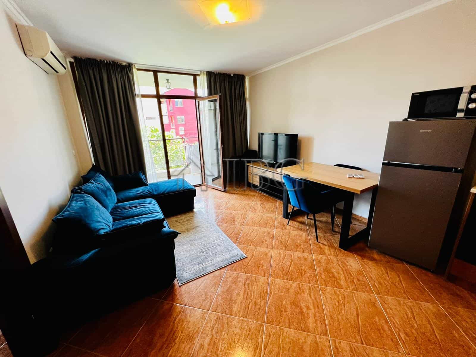 Spacious living room with sofa, TV, and balcony access in Helios Complex, Sveti Vlas.