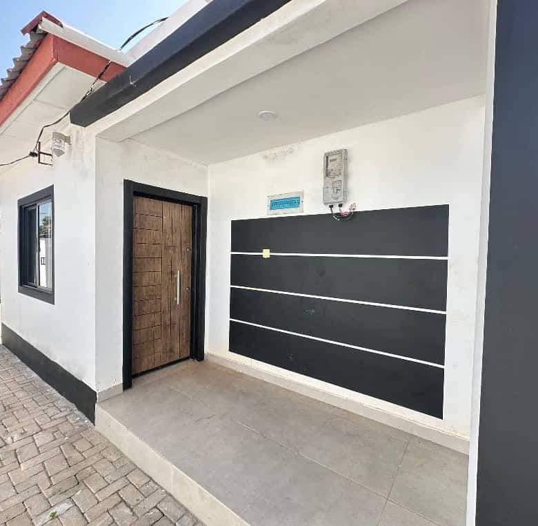 Contemporary villa entrance with black and white exterior in Brufut Gardens, Gambia.